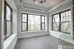 Chicago apartment for rent - A room with large windows and a wooden floor.