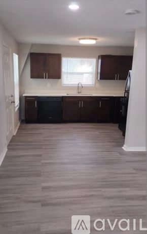 Tampa apartment for rent - A kitchen with wooden floors and dark cabinets.