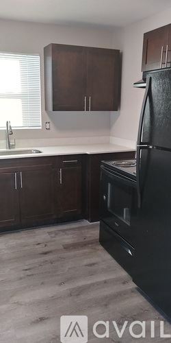 Tampa apartment for rent - A kitchen with brown cabinets and a black refrigerator.