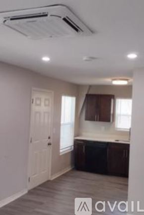 Tampa apartment for rent - A room with a white door and a window with brown curtains.
