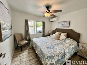 Kailua house for rent - A bedroom with a bed, chair, and ceiling fan.