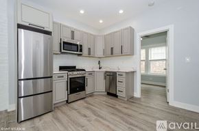 Chicago apartment for rent - A kitchen with a refrigerator, oven, microwave, and cabinets.