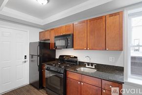 Chicago apartment for rent - A spacious room with wooden floors and two windows.