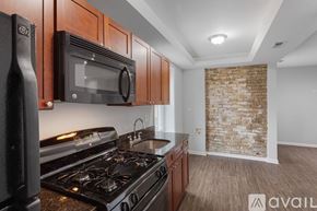 Chicago apartment for rent - A spacious room with wooden floors and two windows.