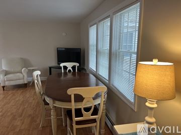 Kennebunk apartment for rent - A living room with a television, a couch, a table with chairs, and a lamp.