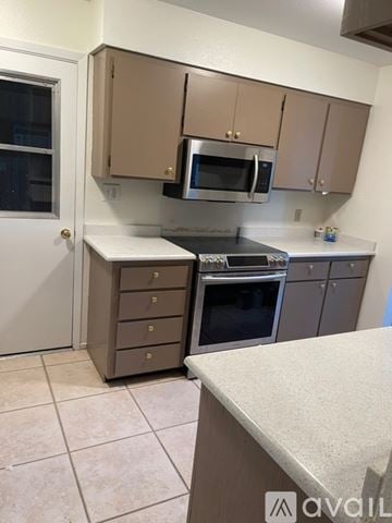 Casa Grande house for rent - A kitchen with a white counter top and brown cabinets.