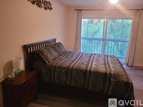 Southport condo for rent - A bedroom with a large bed and a wooden nightstand.