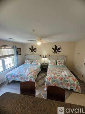 Southport condo for rent - A bedroom with two beds and a ceiling fan.