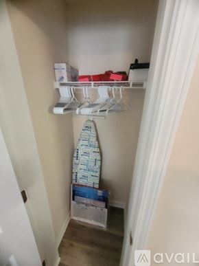 Southport condo for rent - A white closet with clothes hanging and boxes on the floor.