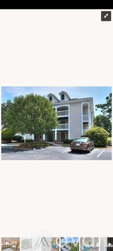 Southport condo for rent - A car is parked in front of a two-story building.