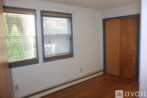 Brooktondale apartment for rent - A bedroom with a bed, a table, and a window with a fan.