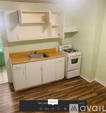 Elizabeth apartment for rent - A small kitchen with a stove, sink, and a door.