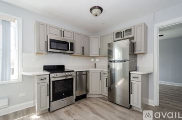 Chicago apartment for rent - A kitchen with a stove top oven, microwave, and refrigerator.