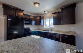 Rapid City apartment for rent - A kitchen with black cabinets and granite countertops.