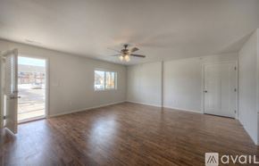 Rapid City apartment for rent - A room with wooden floors and a ceiling fan.