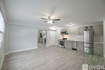 Chicago apartment for rent - A spacious kitchen with a fan on the ceiling and a microwave on the counter.