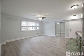Chicago apartment for rent - A spacious room with a ceiling fan and a window with blinds.