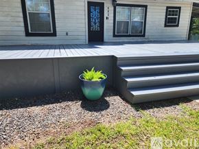 Keithville house for rent - A blue bowl with green plants sits on a gravel area in front of a house.