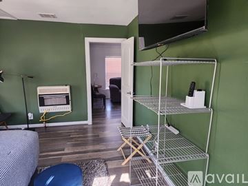 Keithville house for rent - A living room with a green wall and a television mounted on it.