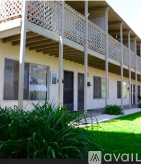 Thousand Oaks apartment for rent - A white building with a balcony and a green plant in front.