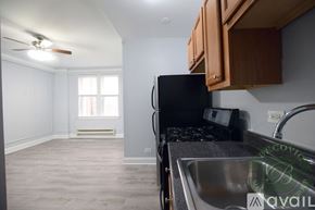 Chicago apartment for rent - A kitchen with a black fridge and a fan on the ceiling.