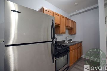 Chicago apartment for rent - A stainless steel refrigerator is in a kitchen with wooden cabinets.