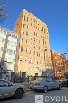 Chicago apartment for rent - A tall building with a row of cars parked in front.