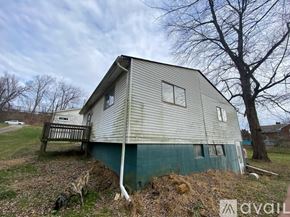 Finleyville house for rent - A house with a green trim and a grey roof with a tree in front.
