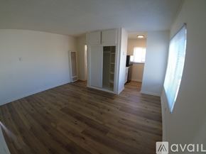 Hawthorne apartment for rent - A room with wooden floors and white walls, with a doorway leading to another room.