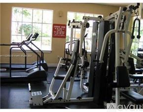 West Palm Beach condo for rent - A gym with a treadmill and a weight machine.