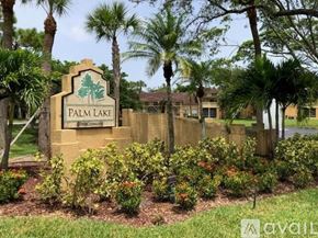 West Palm Beach condo for rent - A sign that says Palm Lake in front of some houses.