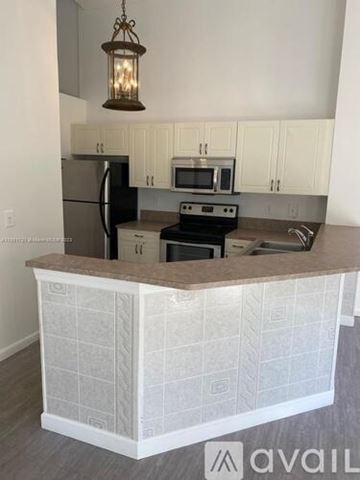 West Palm Beach condo for rent - A kitchen with a white tiled island and a black stove top oven.