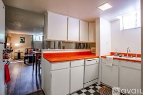 Denver apartment for rent - A kitchen with white cabinets and a black and white checkered floor.