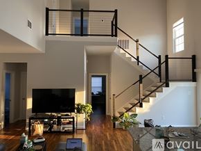 Fort Worth house for rent - A living room with a staircase and a television.