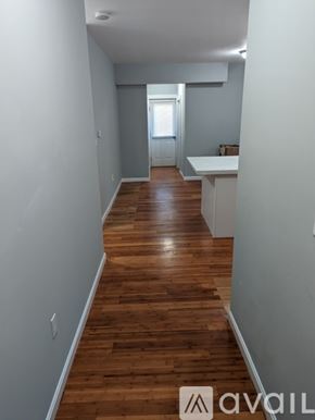 Fall River apartment for rent - A long hallway with wood floors and white walls.