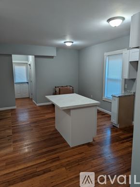 Fall River apartment for rent - A room with wooden floors and a white table.