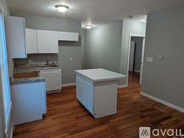 Fall River apartment for rent - A kitchen with white cabinets and a wooden floor.