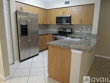 West Palm Beach condo for rent - A kitchen with a granite countertop and stainless steel appliances.