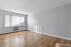 Chicago apartment for rent - A room with wooden floors and a window with blinds.