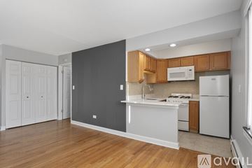 Chicago apartment for rent - A kitchen with wooden cabinets and a white refrigerator.