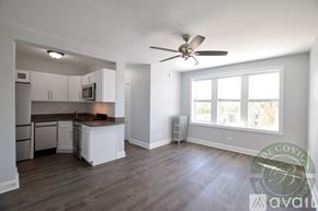 Chicago apartment for rent - A well-lit, spacious kitchen and living room with a wood floor and white walls.