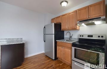 Chicago apartment for rent - A kitchen with wooden cabinets and a stainless steel refrigerator.