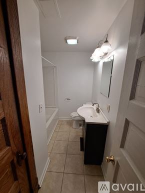 Kalamazoo apartment for rent - A bathroom with a toilet, sink, and mirror.