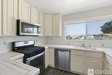 Hermosa Beach house for rent - A kitchen with a black stove and white cabinets.