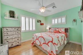 Los Angeles house for rent - A bedroom with a bed, dresser, and ceiling fan.