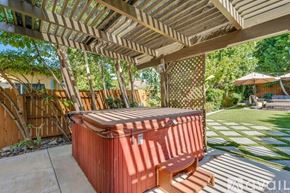 Los Angeles house for rent - A hot tub sits under a wooden pergola in a backyard.