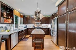 Los Angeles house for rent - A modern kitchen with dark wood cabinets and stainless steel appliances.
