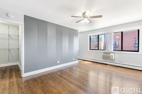 Chicago apartment for rent - A room with a ceiling fan and a window overlooking a city.