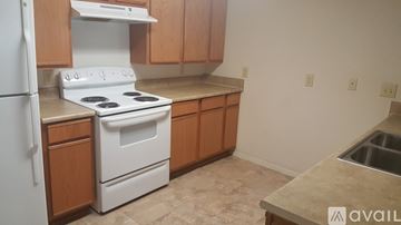 Gatesville apartment for rent - A kitchen with a white stove and wooden cabinets.