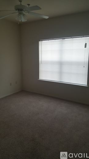 Gatesville apartment for rent - A room with a ceiling fan and a window with blinds.